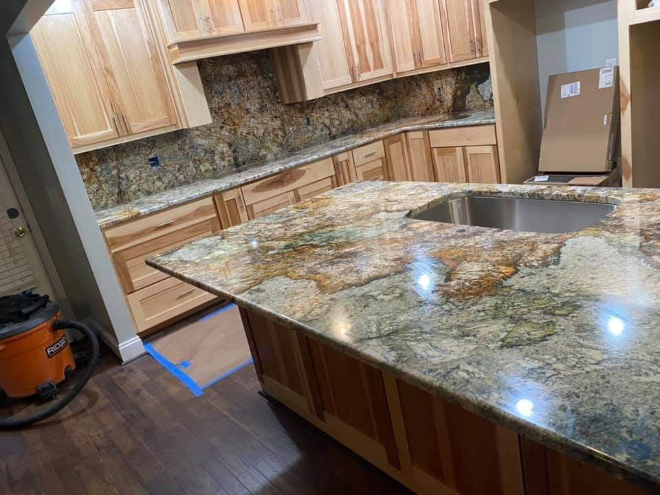 Exotic gold and green quartzite waterfall island with natural wood cabinets