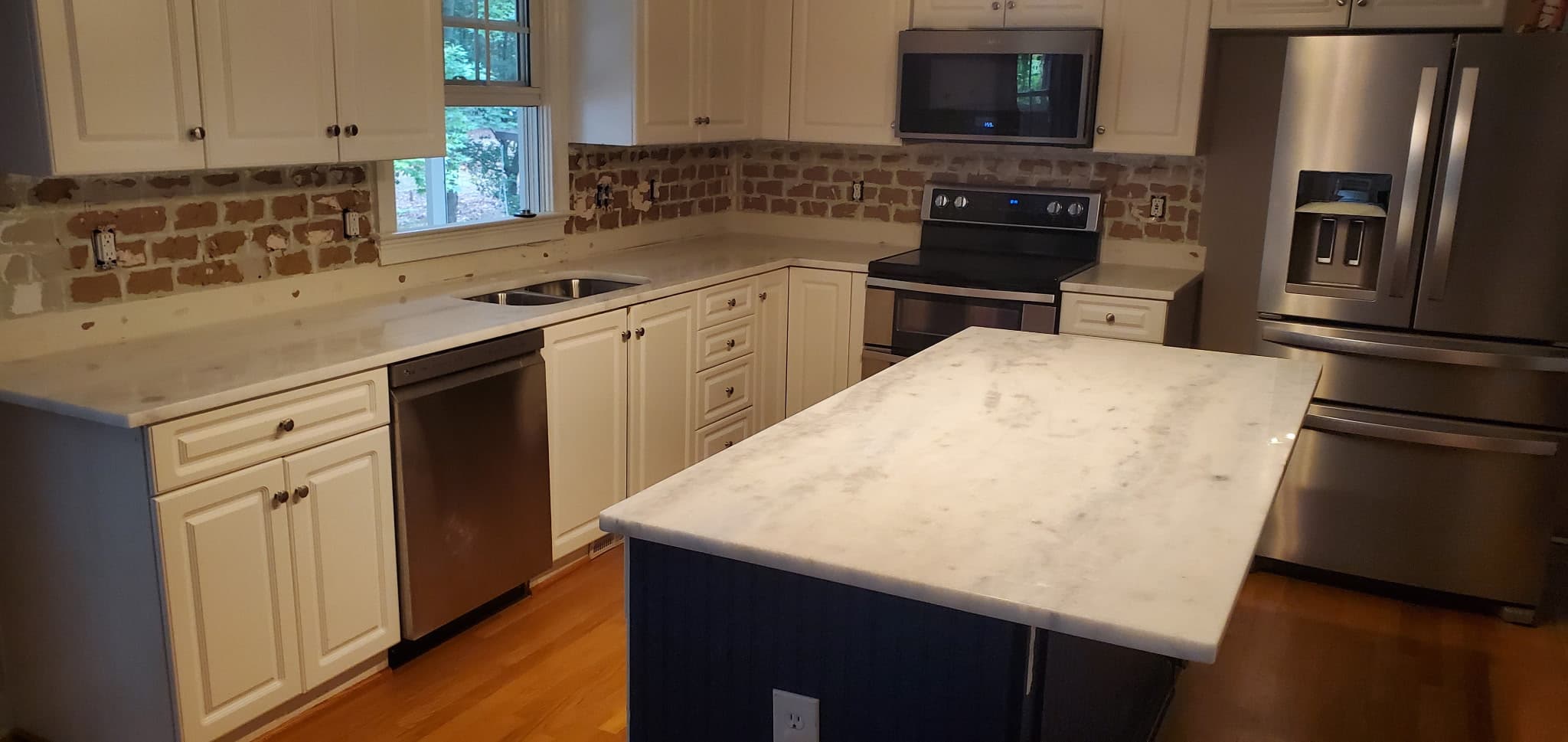 White marble island over navy cabinetry